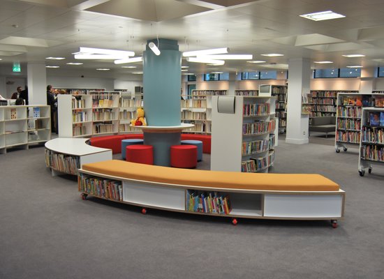 inside of a library with benches and book shelves