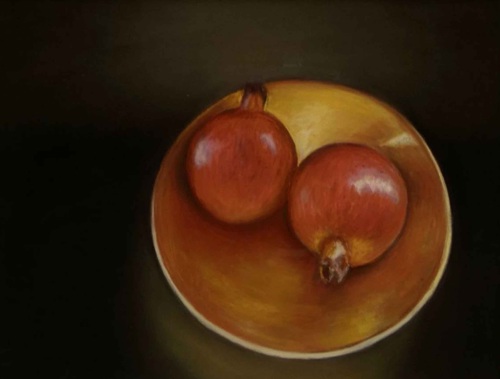 2 Pomegranates sitting on a bowl