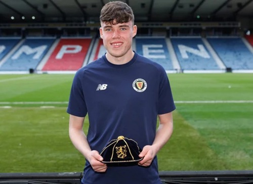 Ben in Hampden holding first cap for Scotland which is black and gold